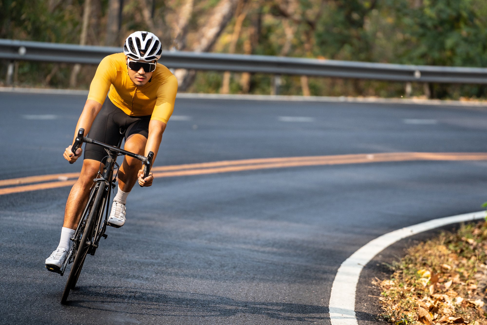 Long distance cyclist in yellow shirt cycling up mountain