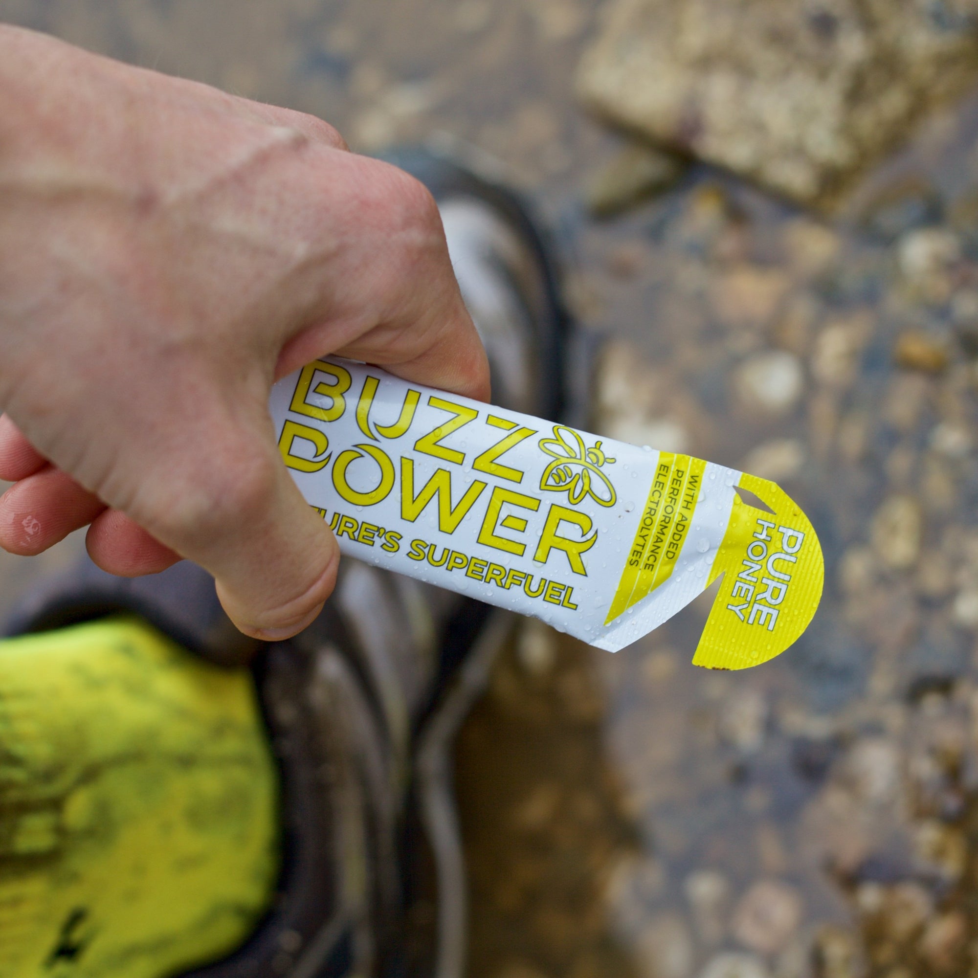 Runner holding sachet of Buzz Power organic honey energy gel